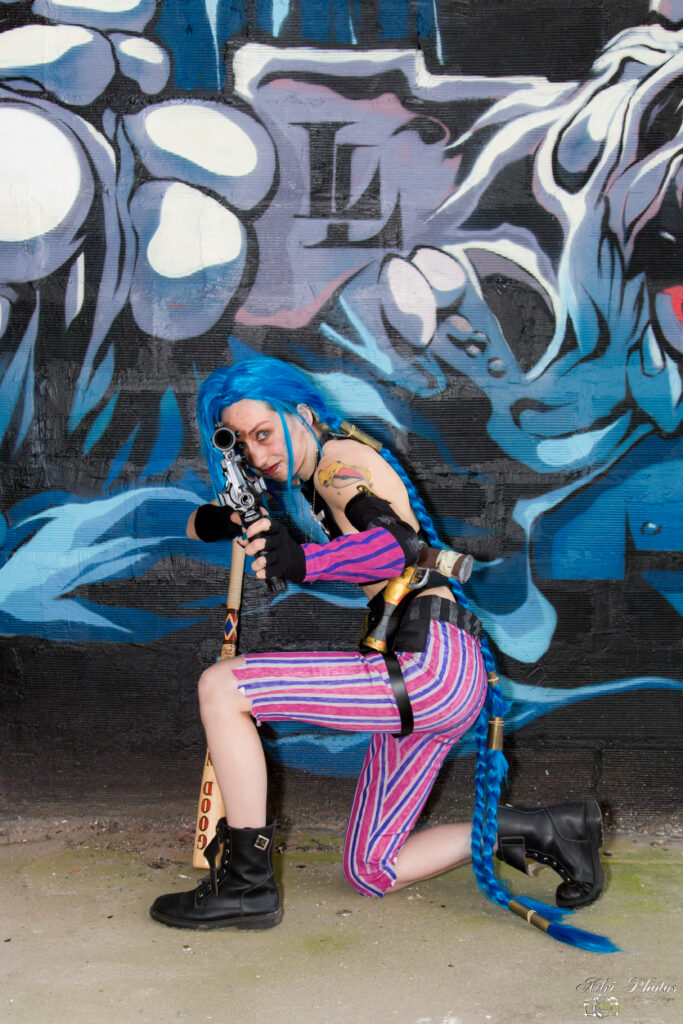 Cosplayeuse Jinx tenant fusil d'assault