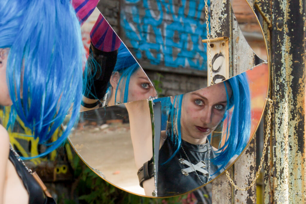 Photo portrait d'une cosplayeuse de Jinx dans miroir cassé