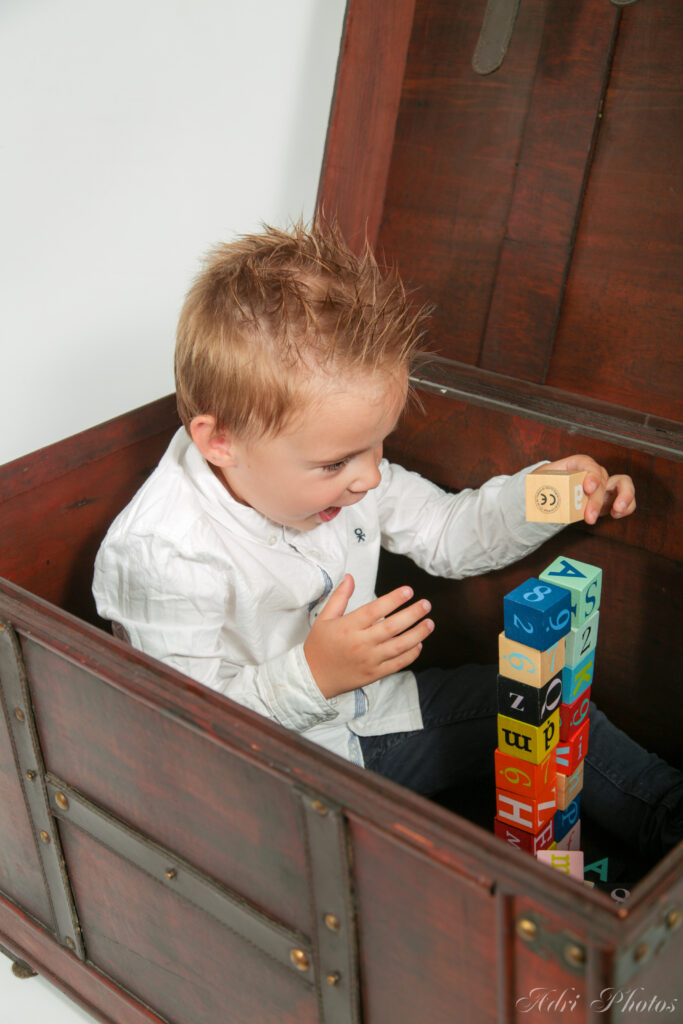 Enfant jouant dans une malle en bois