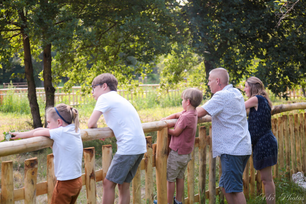 Famille accoudée à une barrière en bois